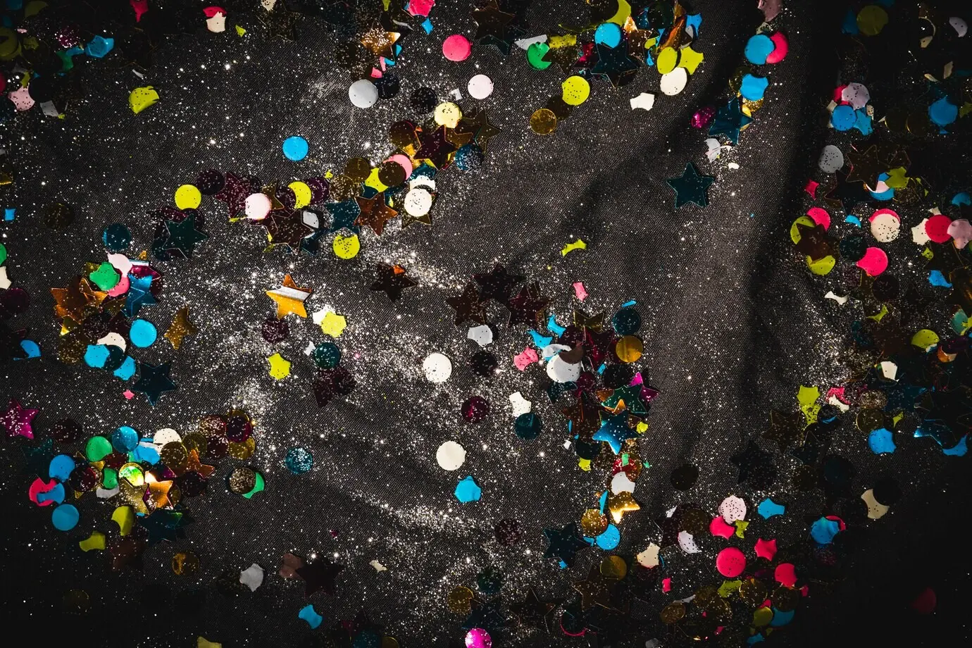 Buntes Konfetti auf dunklem Textil